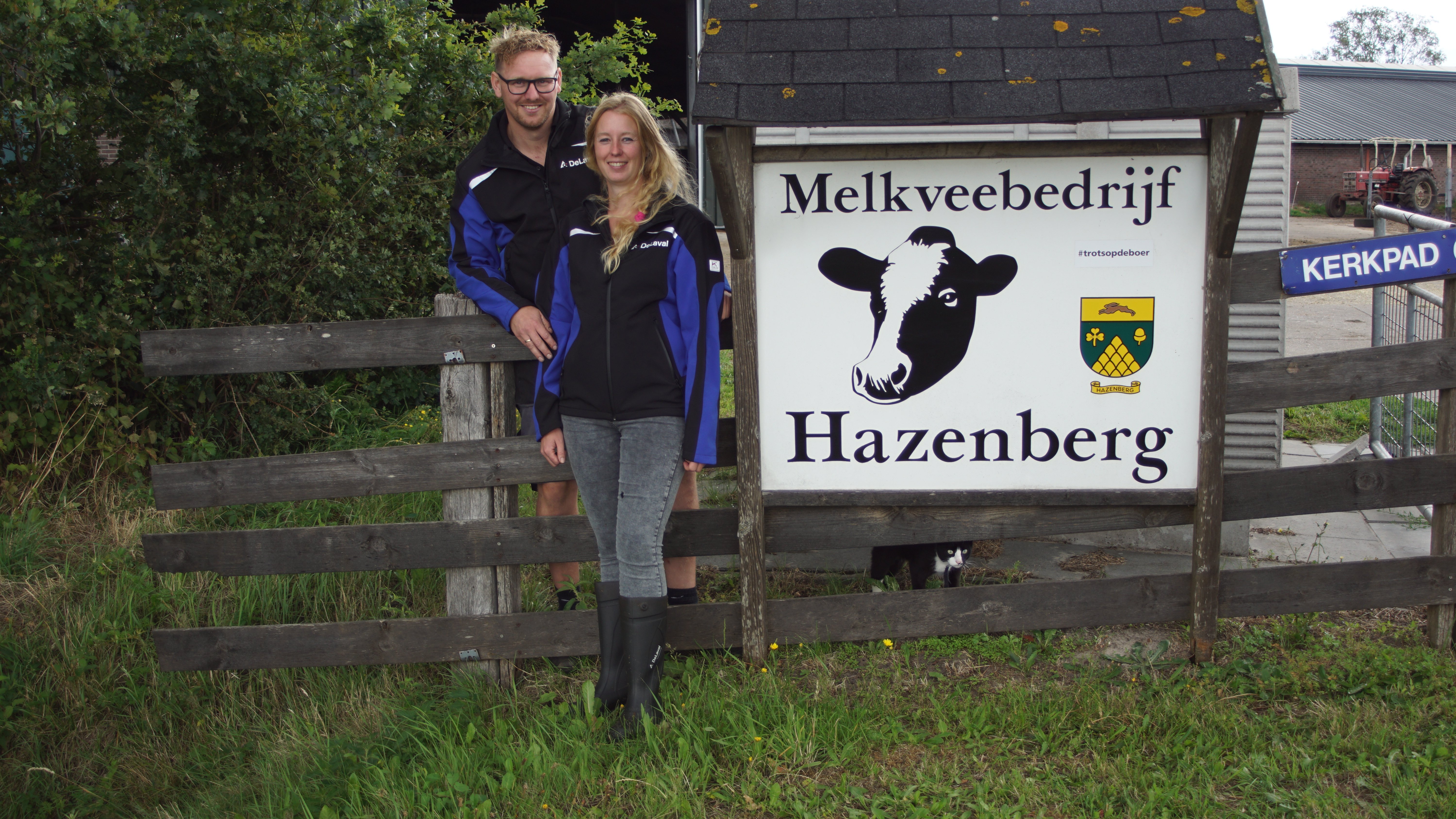 Sander en Els Hazenberg bij het bord van hun melkveebedrijf met VMS melkrobot en DeLaval Plus